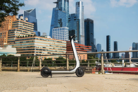 Electric scooter on a city street with skyscrapers in the background