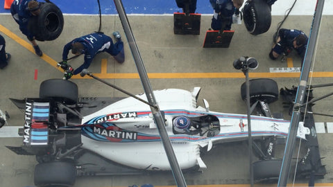 Formula 1 car with 'Martini' branding on a pit stop, surrounded by mechanics.