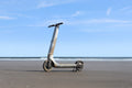 Wet and sandy scooter on a beach with a clear blue sky